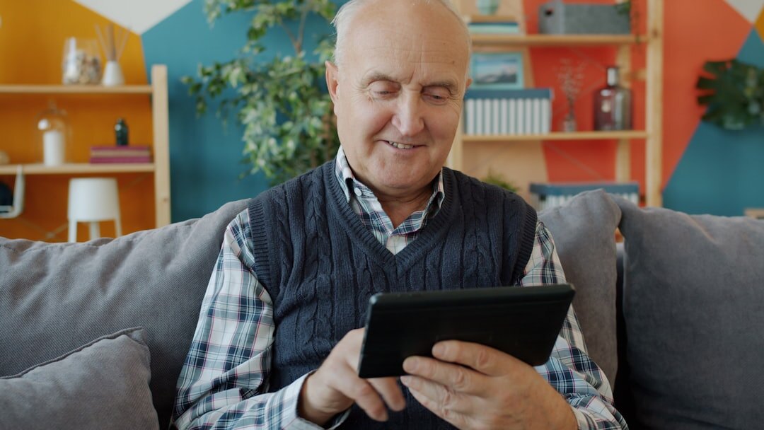 Slovak senior woman reading news on a tablet at home with coffee